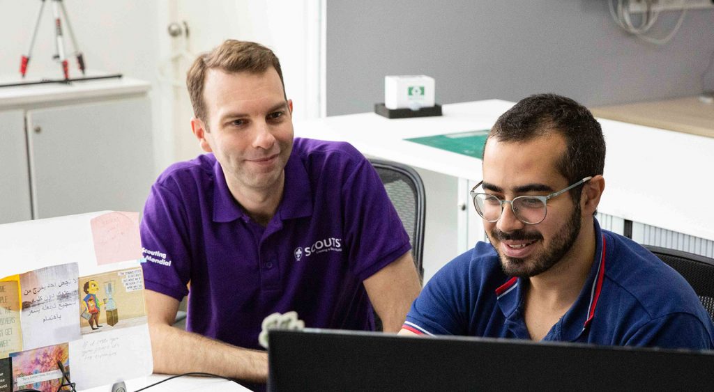 David sat with colleague working