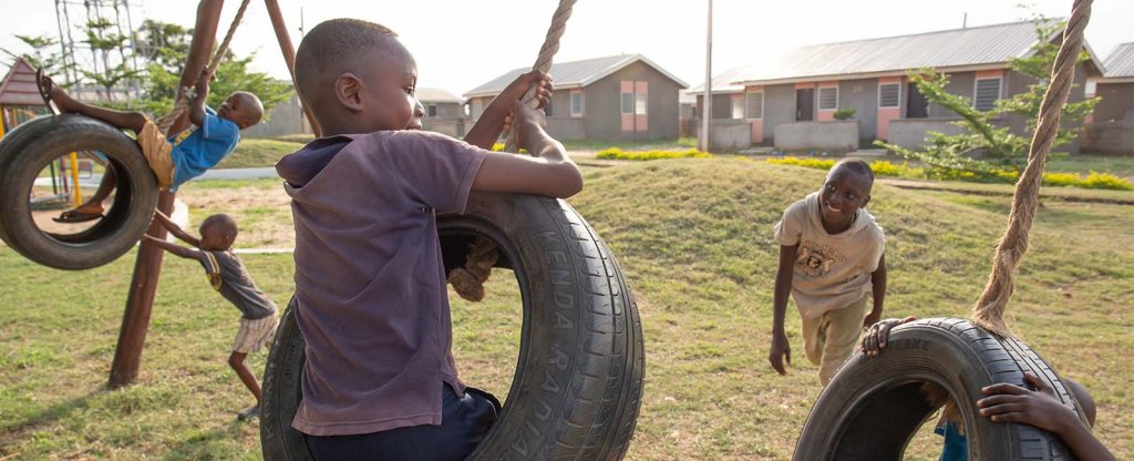Young boys swinging on a tire