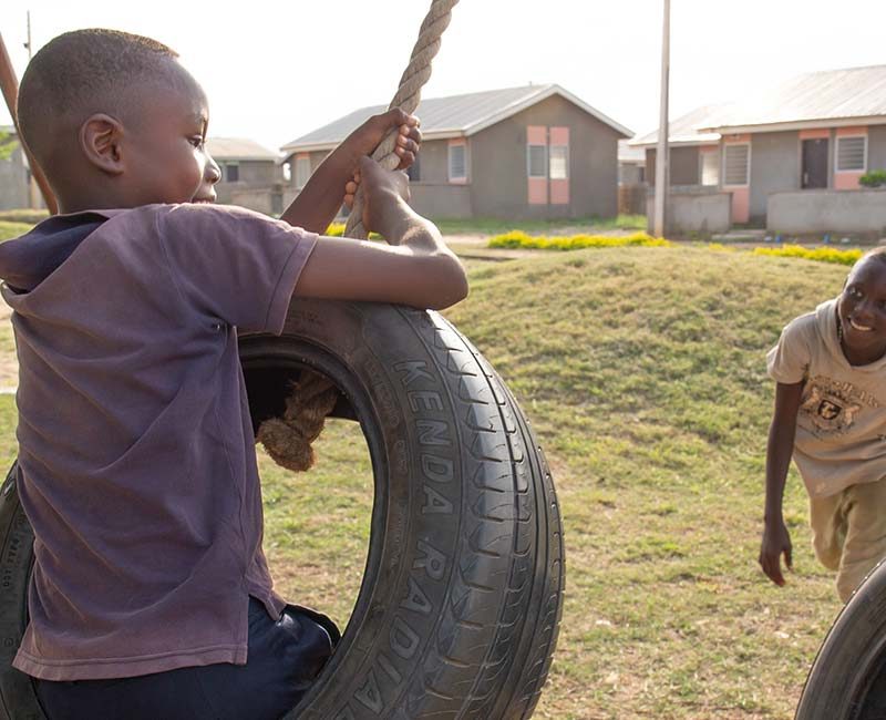Young boys swinging on a tire