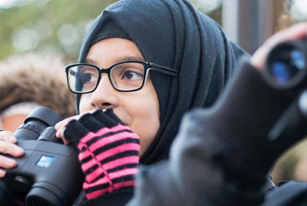 Young girls holding RSPB binoculars