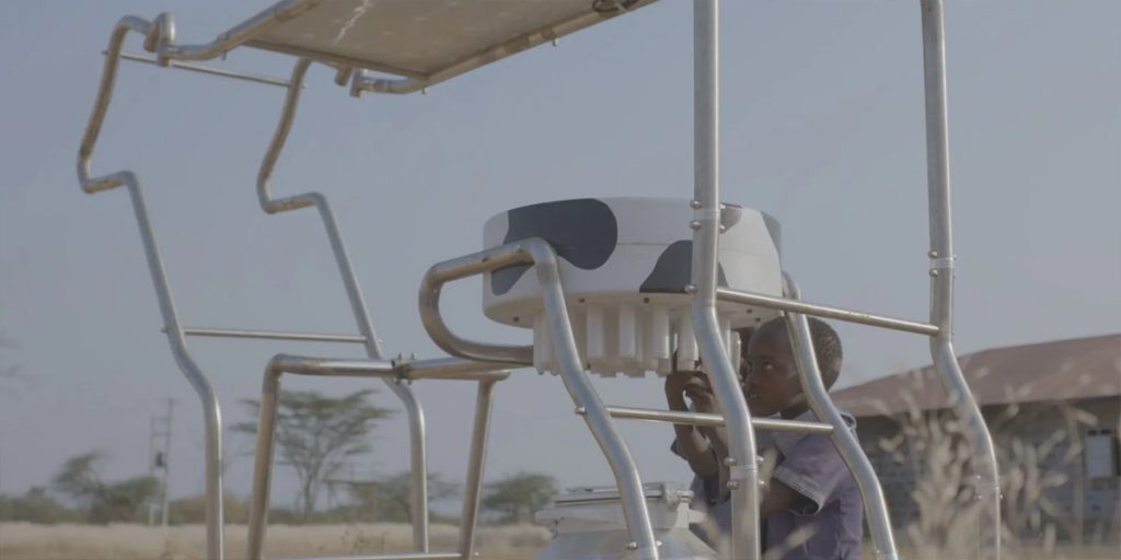 Two children looking at Solar Cow charging station
