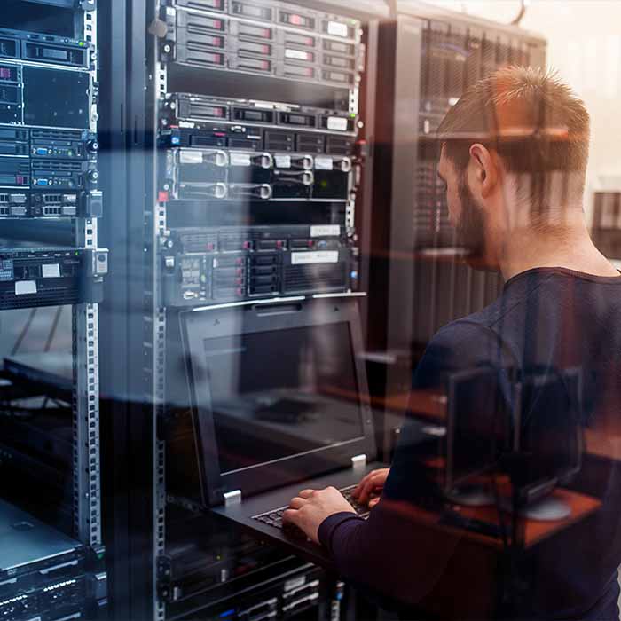 Man working on laptop in data center