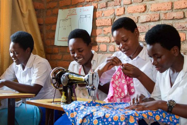 Group of students in African classroom working on sewing machines