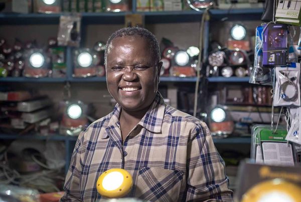 Kenyan man smiling surrounded by shining lights in shop