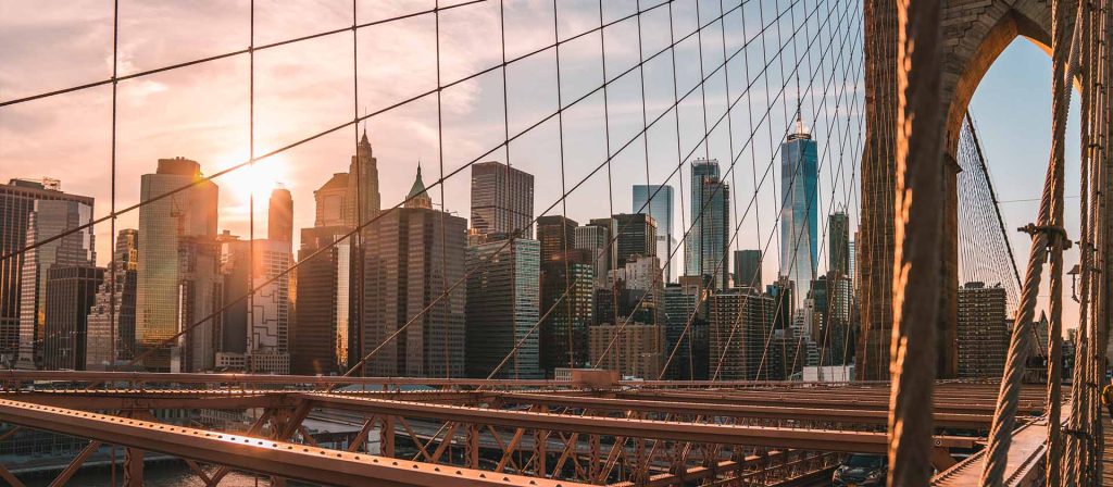 Sun setting over Manhattan skyline from Brooklyn bridge