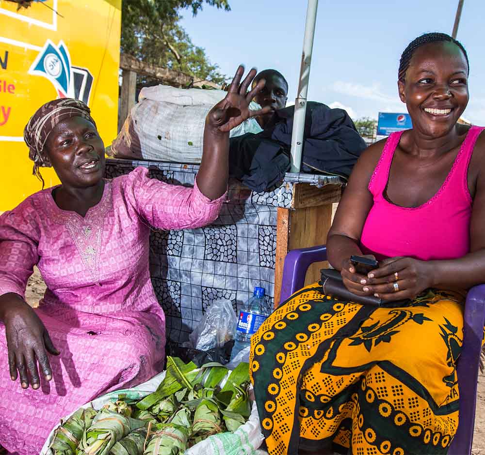 Two female street vendors smiling in conversation