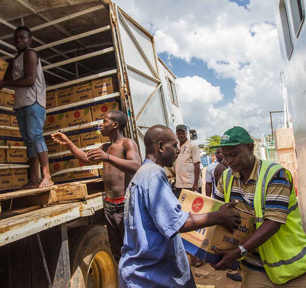 Men unload boxes from delivery vehicle
