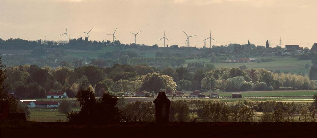 Tree lined hills with wind turbines in the background
