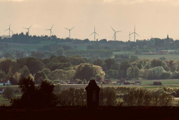 Tree lined hills with wind turbines in the background