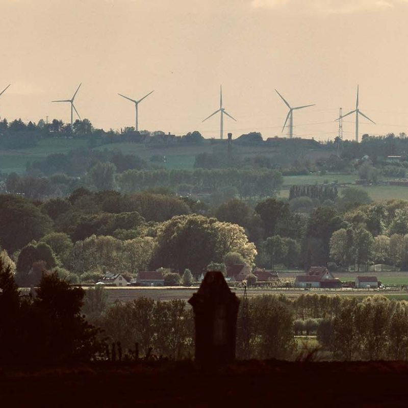Tree lined hills with wind turbines in the background