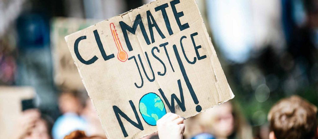 Sign saying "Climate Justice Now"