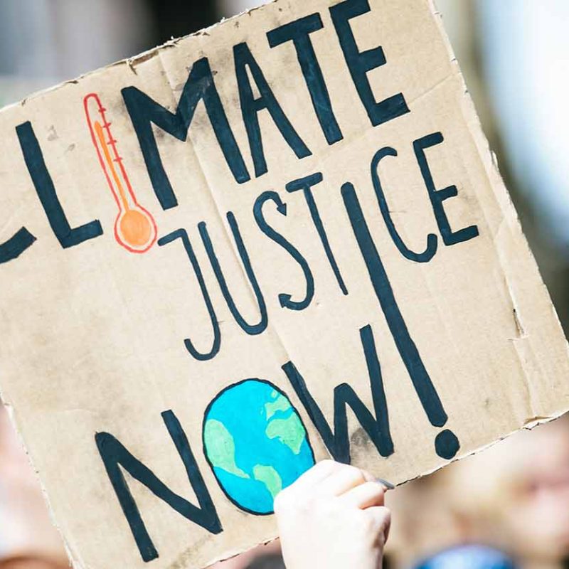 Sign saying "Climate Justice Now"