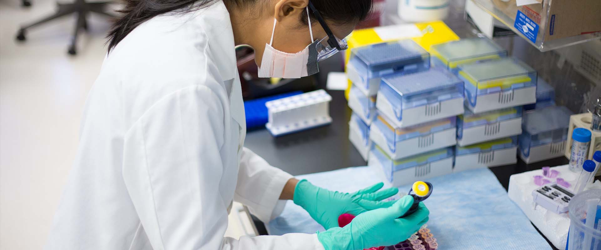 Young scientist in labcoat doing experiments in lab