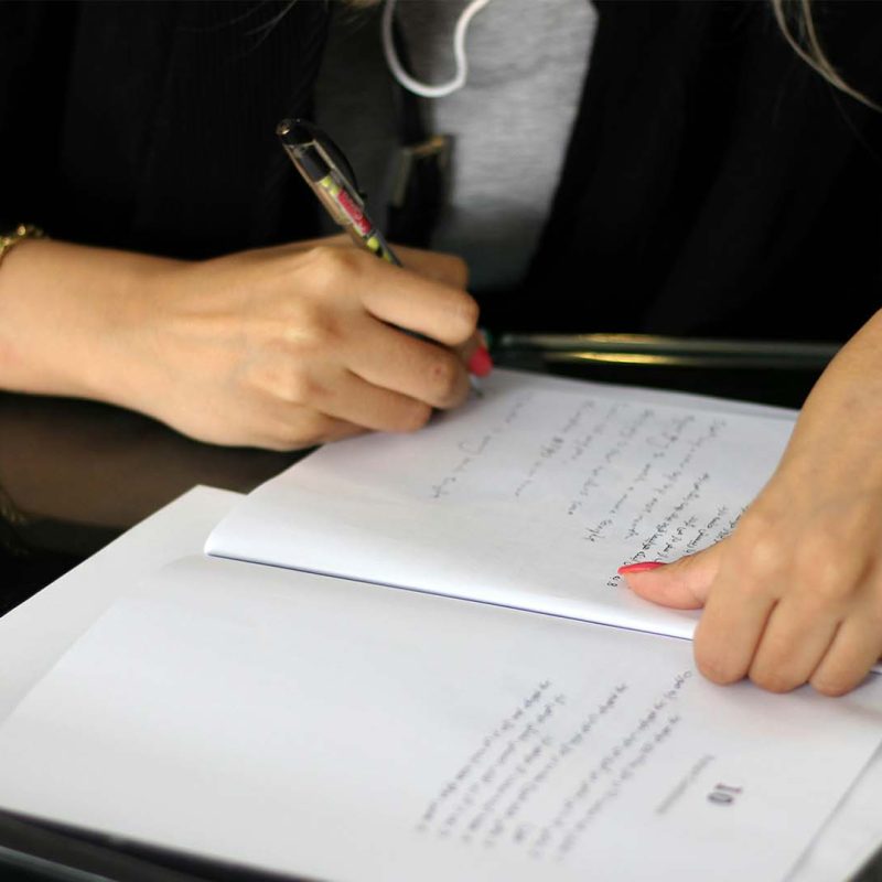 Person writing on paper at desk