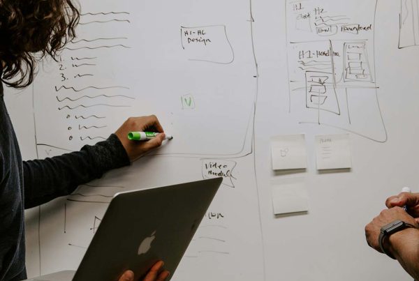 Two colleagues working at a whiteboard