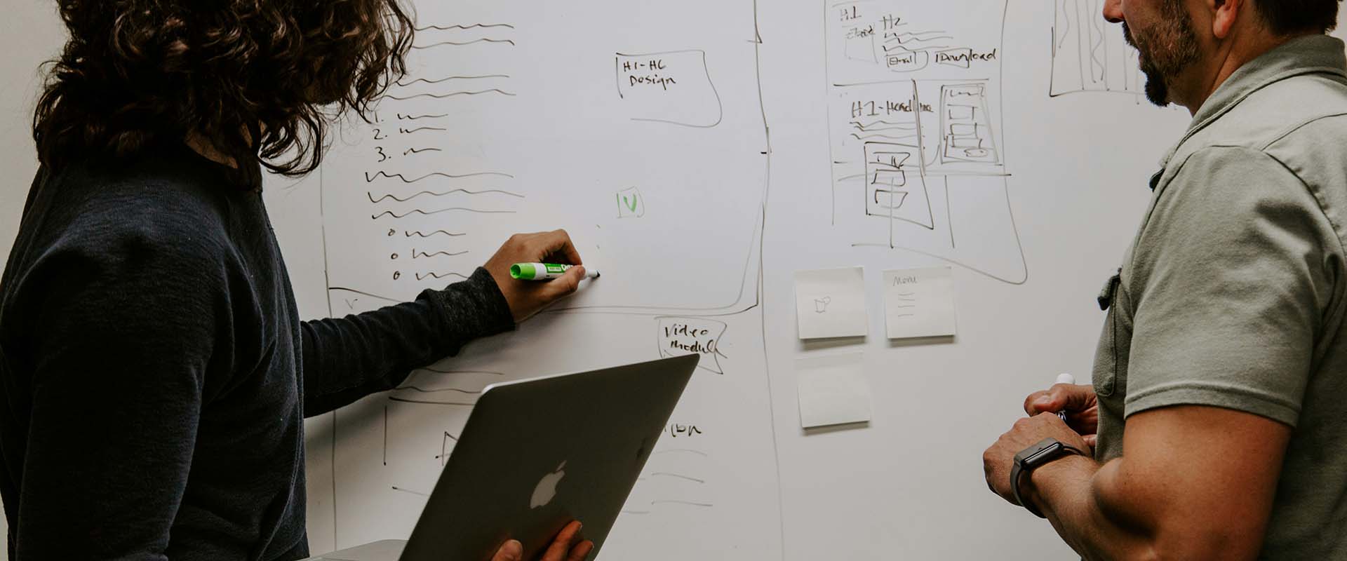 Two colleagues working at a whiteboard
